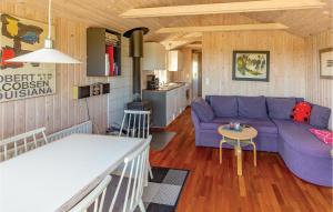 a living room with a purple couch and a kitchen at Holiday Home Æblerosevej in Yderby