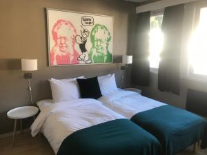 1 dormitorio con 1 cama grande con sábanas blancas y azules en Sogn Hotel, en Vadheim