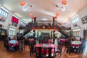 a restaurant with tables and chairs and a staircase at เลาลีฮิลล์รีสอร์ท Laulee hill resort in Chiang Rai