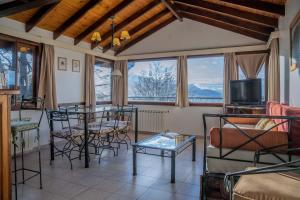 a living room with a table and chairs and a tv at Utaka Cabañas y Apartamentos in Ushuaia