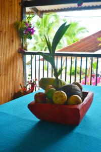 a bowl of fruit on a table with a plant at Posada La Sirena Negra in Nuquí