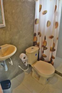 a bathroom with a toilet and a sink at Posada La Sirena Negra in Nuquí