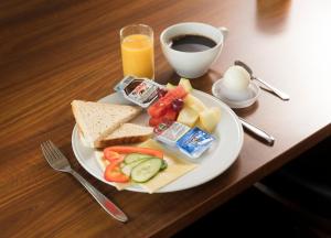 a plate of food with bread and cheese and a cup of coffee at Hotel Vagar in Sørvágur