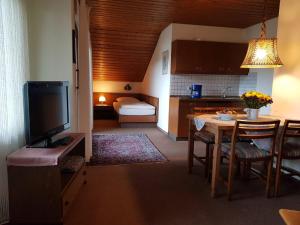 a kitchen and living room with a table and a television at Haus Talblick in Stocksberg