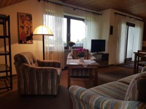 a living room with two couches and a tv at Haus Talblick in Stocksberg +1 photo