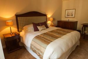 1 cama grande en una habitación de hotel con 2 lámparas en The Woodhouse Arms, en Grantham