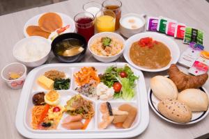 a table with a tray of food and bowls of food at Kuretake-INN Omaezaki in Omaezaki