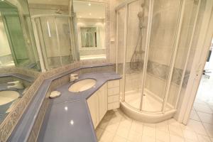 a bathroom with two sinks and a shower at 2, 3 and 4 bedroom sea view Forville Apartments 5 mins from the Palais in Cannes