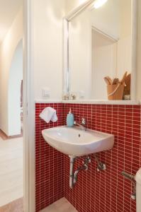 baño con lavabo blanco y azulejos rojos en Naxos Asty, en Naxos Chora 16 fotos más