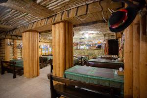 ヤレムチャにあるNebokraiの木製の柱とテーブル、帽子のあるレストラン