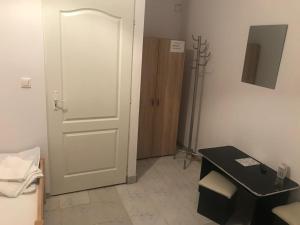 Zimmer mit einer weißen Tür und einem schwarzen Tisch in der Unterkunft Casa albastră in Marghita