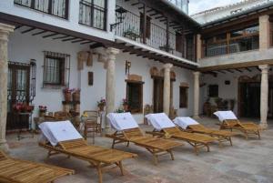 un grupo de sillas de madera sentadas en un patio en Hotel Rural Casa Grande Almagro, en Almagro