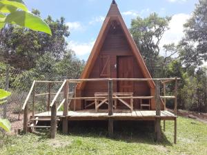 Cabaña de madera pequeña con techo de paja en Chalés e Camping do Robinho 1, en São Thomé das Letras