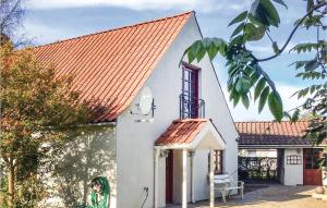 una pequeña casa blanca con techo naranja en Nice Home In rsted With 3 Bedrooms And Wifi, en Udbyhøj