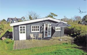 a small cabin with chairs and an umbrella on a deck at Madseløkke in Allinge