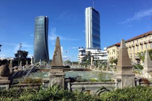 a fountain in the middle of a city with tall buildings at Welcome Home in Milan