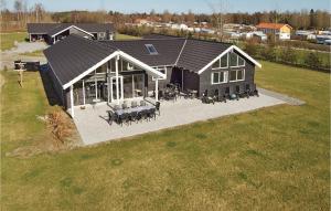 Elle offre une vue sur une grande maison dotée d'une terrasse. dans l'établissement Nice Home In Idestrup With Sauna, à Bøtø By