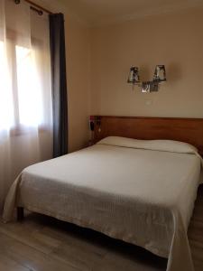 a bedroom with a white bed with a window at HOTEL IVATO , Airport in Antananarivo