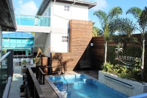 a house with a swimming pool in front of a building at Barefoot Caye Caulker Hotel in Caye Caulker