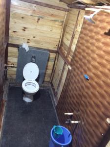 a bathroom with a toilet in a wooden wall at Blue Corner Beach Huts & Restaurant in Benaulim