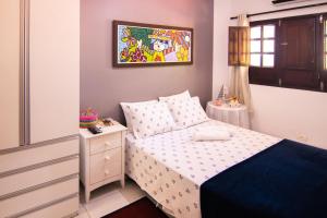 a small bedroom with a bed and a night stand at Flat Bantu - Aconchegante Flat no coração de Porto de Galinhas - Aqui seu pet é bem vindo in Porto De Galinhas