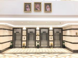 a row of elevators in a building with pictures on the wall at Zaha Al Madina Hotel in Medina