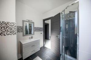 Un baño blanco con lavabo y ducha. en Appartamento 23 Pax in Villa Francesca by Ville in Palermo, en Casteldaccia 42 fotos más