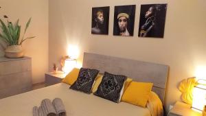 - une chambre dotée d'un lit avec 4 photos sur le mur dans l'établissement Il Vecchio Ginepro, à Capoterra