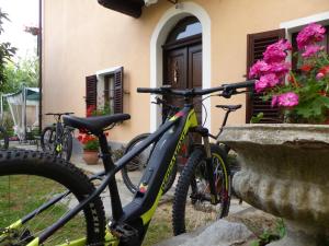 duas bicicletas estacionadas em frente a um edifício com flores em Casa Borio em Bioglio