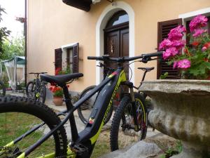 dos bicicletas estacionadas frente a un edificio con flores en Casa Borio, en Bioglio