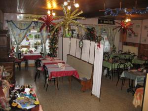 a restaurant with tables and chairs and christmas decorations at Auberge Hôtel chambre Tout Confort B-B et Restaurant Les Colombes in Sugny