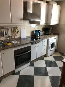 a kitchen with white appliances and a checkered floor at Casa Elena in Cuevas del Almanzora