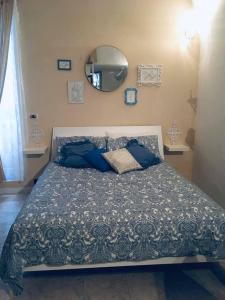 - un lit avec des oreillers bleus et un miroir dans la chambre dans l'établissement CASA VACANZE OCCHI BLU (BEB), à Molfetta