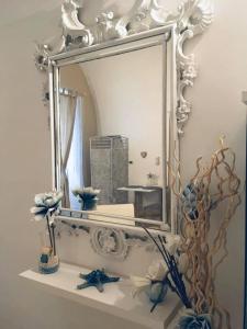 un miroir assis au-dessus d'une étagère blanche dans l'établissement CASA VACANZE OCCHI BLU (BEB), à Molfetta