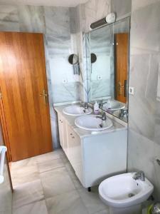 a bathroom with two sinks and a toilet and a mirror at Casa Elena in Cuevas del Almanzora