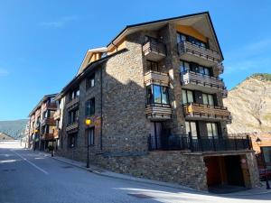 a stone building with balconies on the side of a street at Apartamentos Canillo Ribagrossa 3000 in Canillo