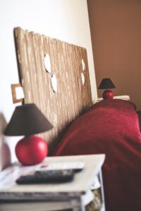 a bed with a red head board and a table with a remote control at Il Mare Di Roma in Lido di Ostia