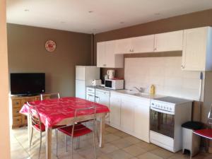 una cocina con una mesa con un mantel rojo. en Maison Gauthier, en Saint-Désirat