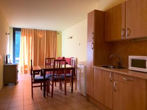 a kitchen with a table and chairs and a microwave at Apartamentos Canillo Ribagrossa 3000 in Canillo