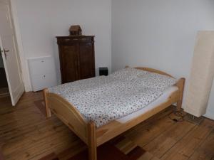 ein kleines Schlafzimmer mit einem Bett und einer Kommode in der Unterkunft Apartment Stadtoase Wilmersdorf in Berlin