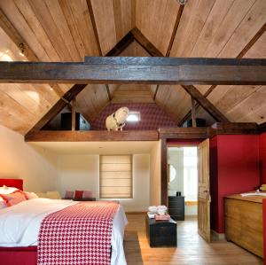 um quarto com uma cama grande e tectos em madeira em De Zevende Hemel em Merendree
