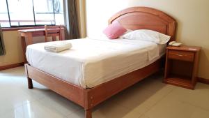 a bed with a wooden headboard in a room at Hotel Centenario in Puerto Maldonado