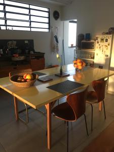 a kitchen with a table with a bowl of fruit on it at Bom Retiro, literature & coffee in São Paulo