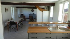 eine Küche und ein Esszimmer mit einem Tisch und Stühlen in der Unterkunft Le Gros Tilleul in Chepoix