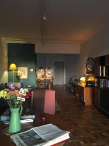 ein Wohnzimmer mit einem Tisch mit Blumen darauf in der Unterkunft Bom Retiro, literature & coffee in São Paulo