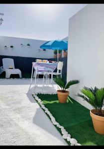 a table and umbrella on a patio with plants at Loft La ISLA in Playa Blanca