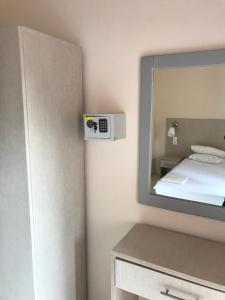 ein Schlafzimmer mit einem Spiegel und einem Bett in einem Zimmer in der Unterkunft Eleni Kandilari Rooms in Kókkinon Nerón