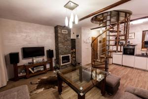 a living room with a glass table and a spiral staircase at APARTAMENT NA SZLAKU in Szczawnica