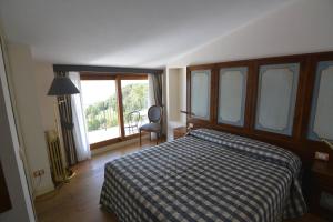 a bedroom with a bed and a chair and a window at Il Camino in Tignale