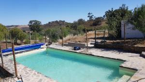 a pool of blue water in a yard at Monte Das Ferrarias in Mesquita